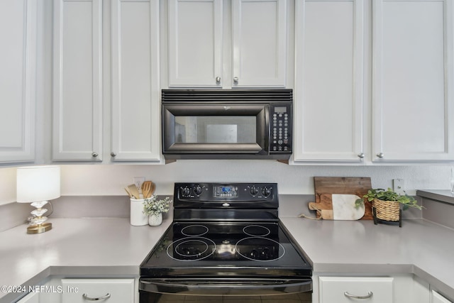 kitchen with black appliances and white cabinets