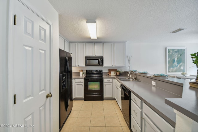 kitchen featuring black appliances, white cabinets, sink, light tile patterned flooring, and a textured ceiling