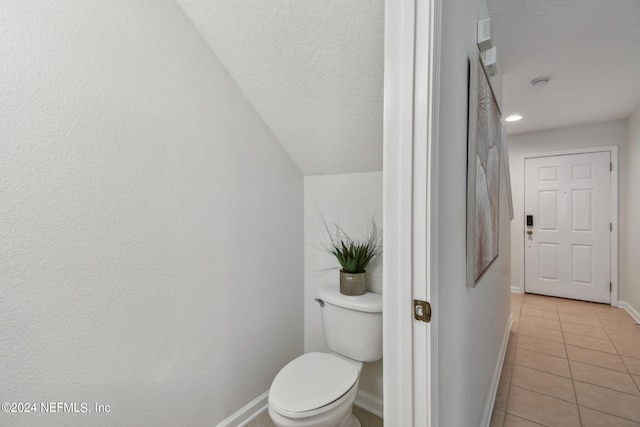 bathroom featuring tile patterned flooring, a textured ceiling, and toilet