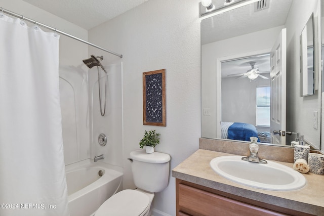 full bathroom with ceiling fan, vanity, a textured ceiling, shower / bath combo with shower curtain, and toilet