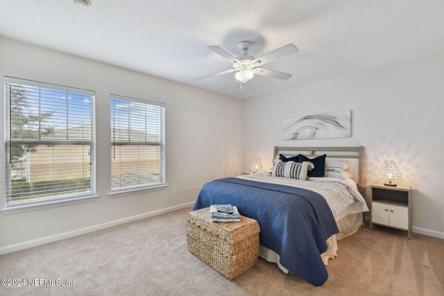 bedroom with carpet, a textured ceiling, and ceiling fan