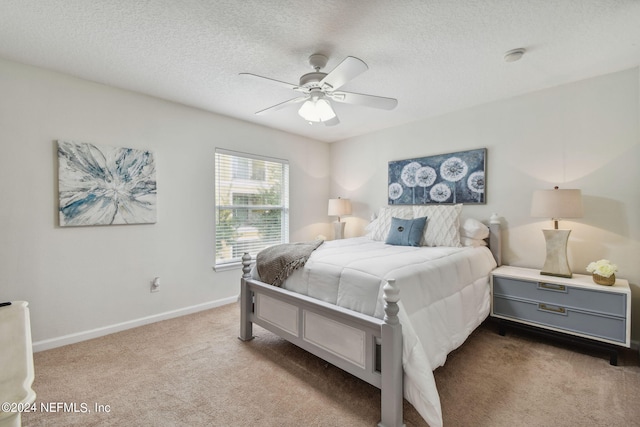 carpeted bedroom featuring ceiling fan and a textured ceiling