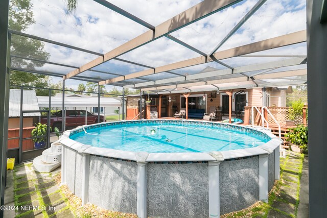 view of pool featuring a shed, a patio area, and a lanai