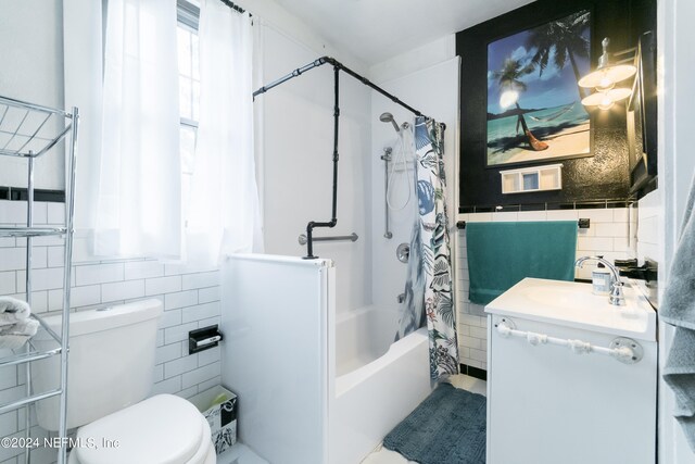 full bathroom featuring vanity, toilet, tile walls, and shower / bath combo