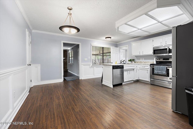 kitchen featuring kitchen peninsula, pendant lighting, white cabinetry, appliances with stainless steel finishes, and dark hardwood / wood-style flooring