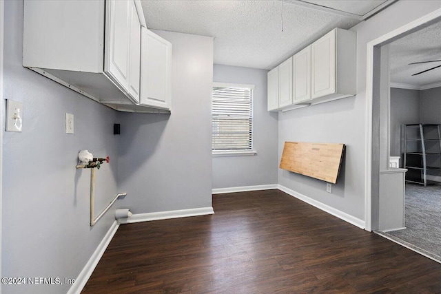 laundry room with cabinets, a textured ceiling, dark wood-type flooring, and ceiling fan