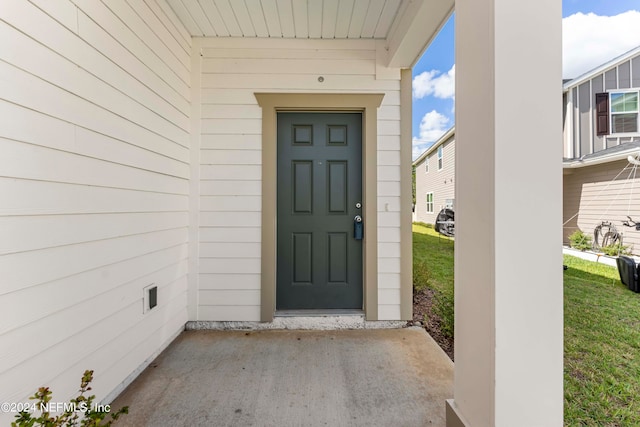 doorway to property with a lawn