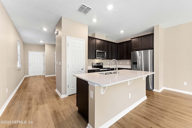 7716 Merchants Way, Jacksonville, FL 32222 - kitchen featuring a kitchen island with sink, stainless steel appliances, light wood-type flooring, visible vents, and light countertops