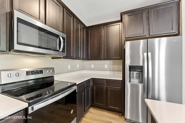 7716 Merchants Way, Jacksonville, FL 32222 - kitchen featuring light countertops, stainless steel appliances, dark brown cabinets, and light wood-style flooring