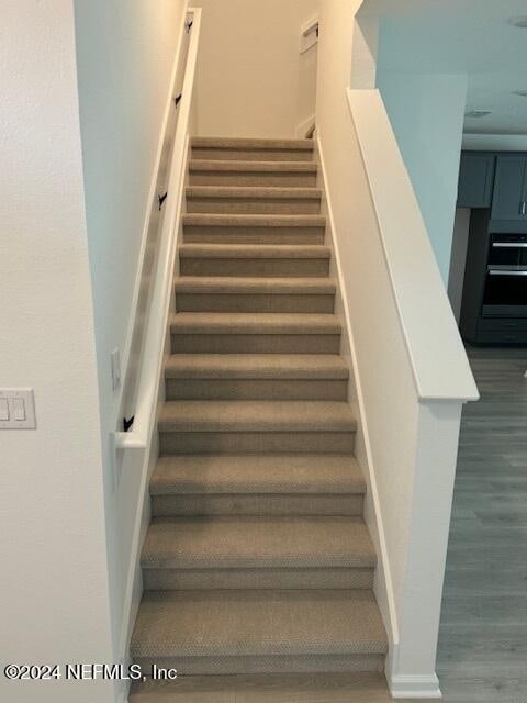 stairs featuring hardwood / wood-style flooring