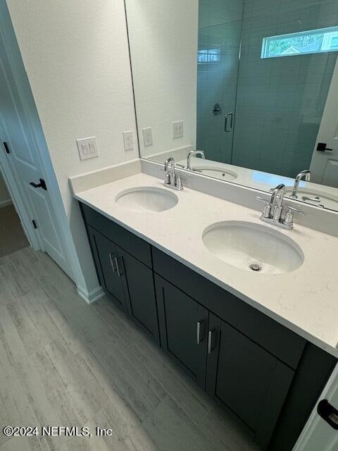 bathroom featuring vanity, an enclosed shower, and hardwood / wood-style flooring