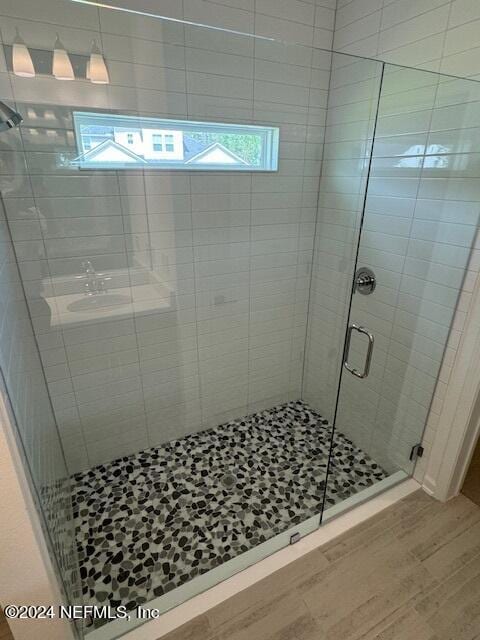 bathroom featuring a shower with door and hardwood / wood-style floors