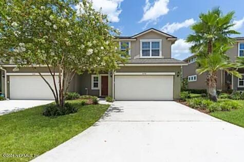 view of front of property featuring a front lawn and a garage