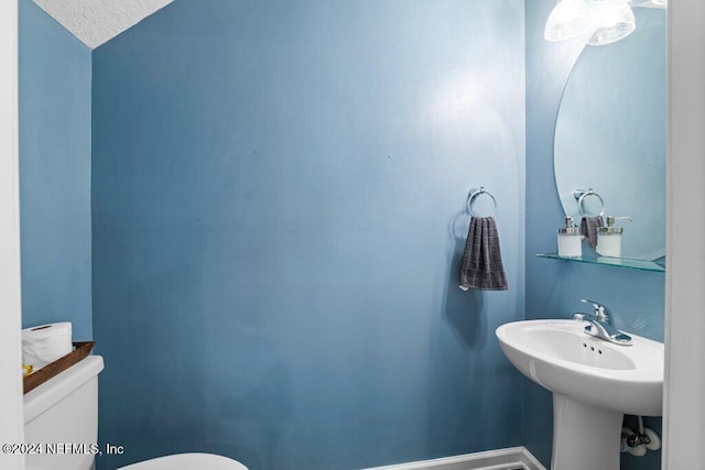 bathroom with a textured ceiling and toilet