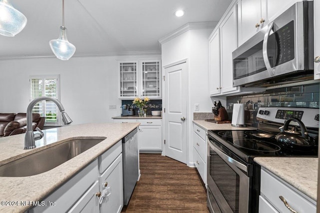 kitchen with sink, pendant lighting, decorative backsplash, white cabinets, and appliances with stainless steel finishes