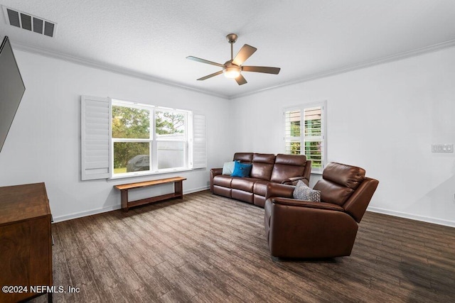 living room with crown molding, plenty of natural light, and dark hardwood / wood-style floors