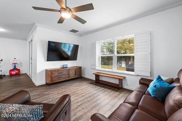 living room featuring ceiling fan, crown molding, and light hardwood / wood-style flooring