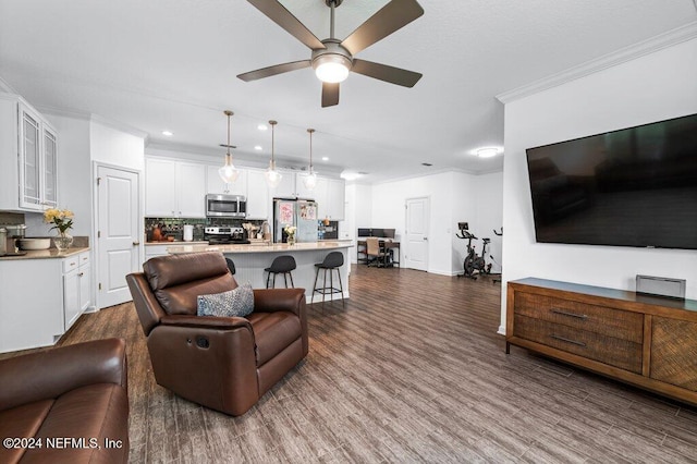 living room with ceiling fan, dark hardwood / wood-style flooring, and crown molding