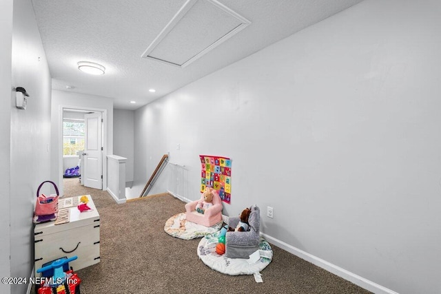 playroom featuring carpet floors and a textured ceiling