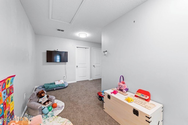 recreation room featuring carpet and a textured ceiling