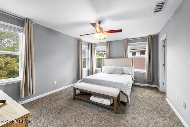 carpeted bedroom featuring a textured ceiling and ceiling fan