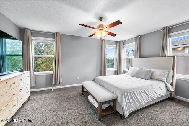 carpeted bedroom featuring ceiling fan and a textured ceiling