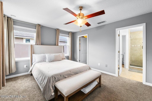 bedroom with carpet, a textured ceiling, ensuite bath, and ceiling fan