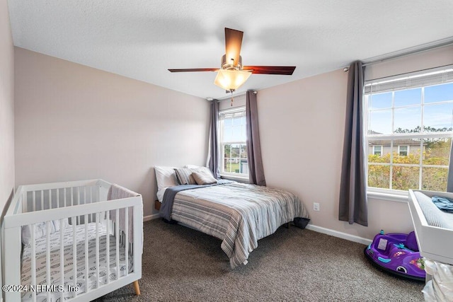 bedroom featuring ceiling fan, carpet, and a textured ceiling