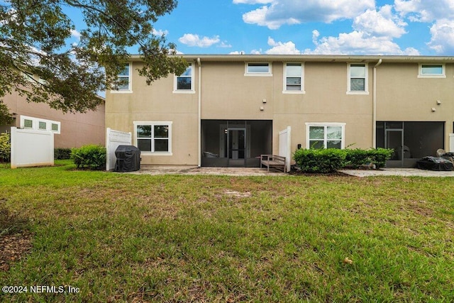 back of property featuring a sunroom and a yard