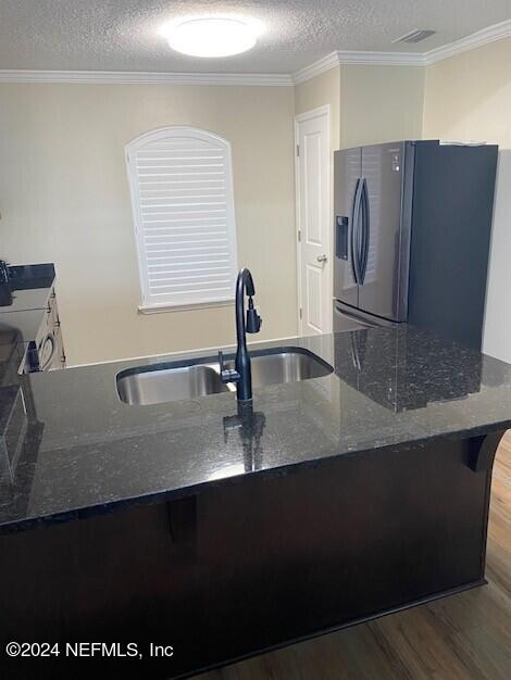 kitchen with hardwood / wood-style floors, stainless steel fridge, sink, and crown molding