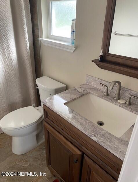 bathroom featuring tile patterned flooring, vanity, and toilet