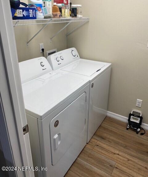 washroom with wood-type flooring and washer and dryer