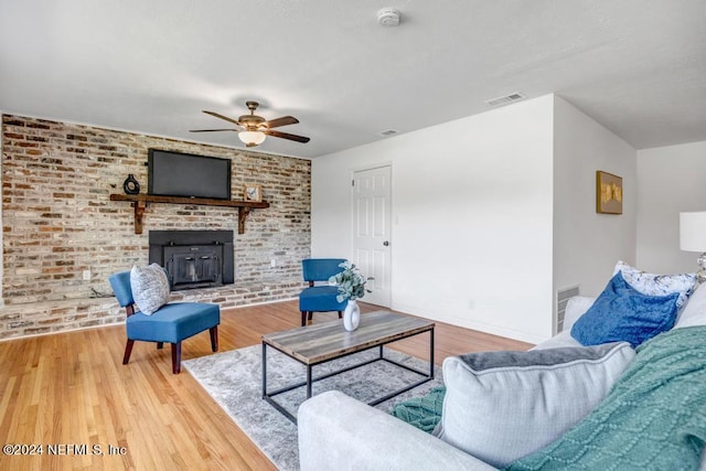 living room featuring hardwood / wood-style flooring, ceiling fan, and brick wall