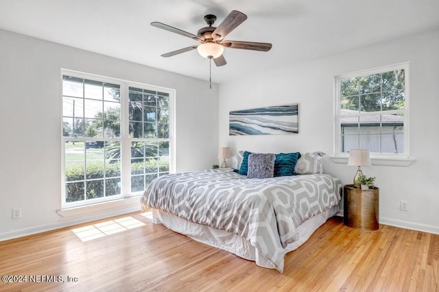 bedroom with light wood-type flooring, multiple windows, and ceiling fan