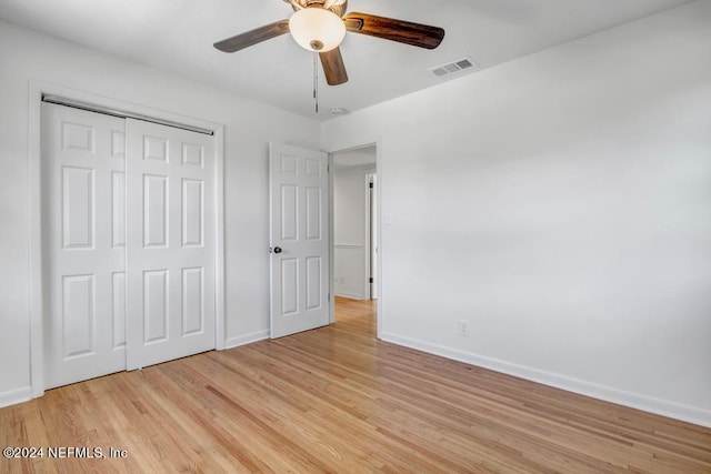 unfurnished bedroom with a closet, light hardwood / wood-style flooring, and ceiling fan