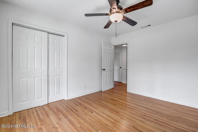 unfurnished bedroom featuring a closet, light hardwood / wood-style flooring, and ceiling fan