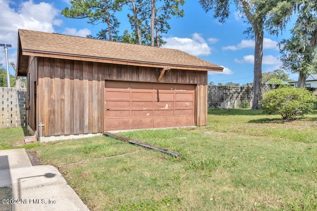 view of outbuilding with a garage and a lawn