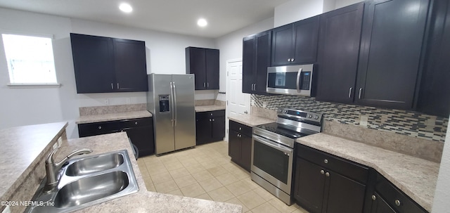 kitchen featuring light tile patterned floors, stainless steel appliances, sink, and decorative backsplash