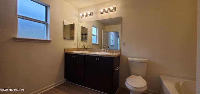 bathroom with a tub to relax in, vanity, toilet, and wood-type flooring