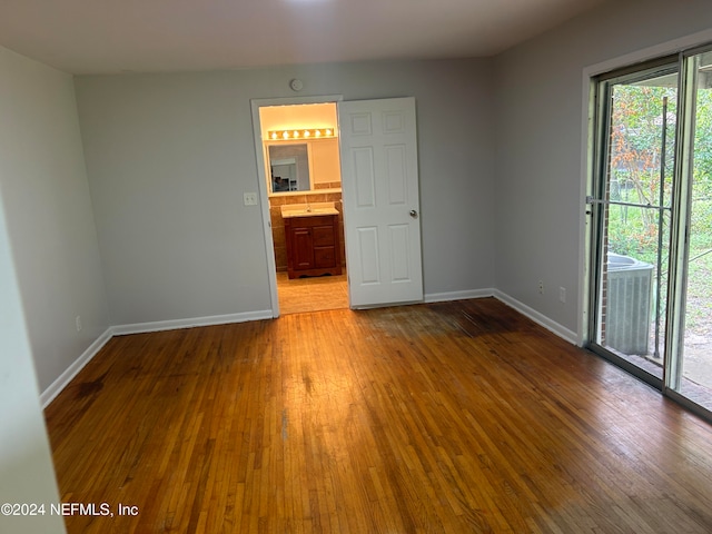 unfurnished room featuring hardwood / wood-style flooring and sink