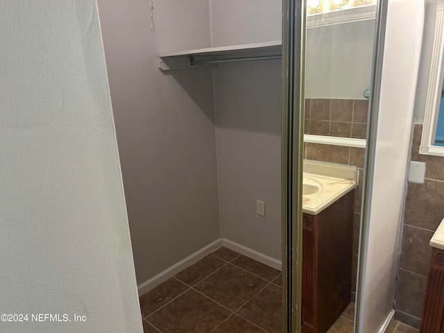 bathroom with tile patterned floors, tile walls, and vanity