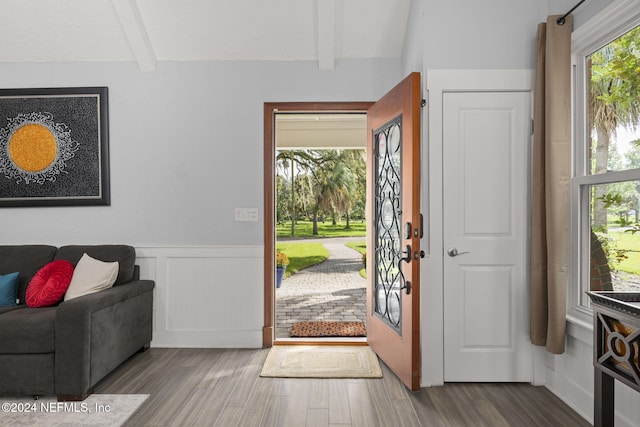 entryway featuring beam ceiling, a healthy amount of sunlight, and hardwood / wood-style flooring