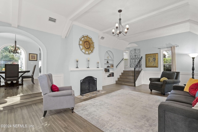 living room featuring vaulted ceiling with beams, hardwood / wood-style flooring, plenty of natural light, and built in shelves