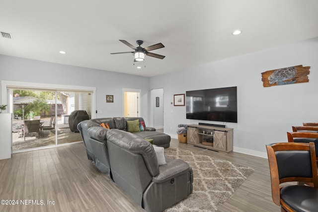 living room featuring ceiling fan and light hardwood / wood-style flooring