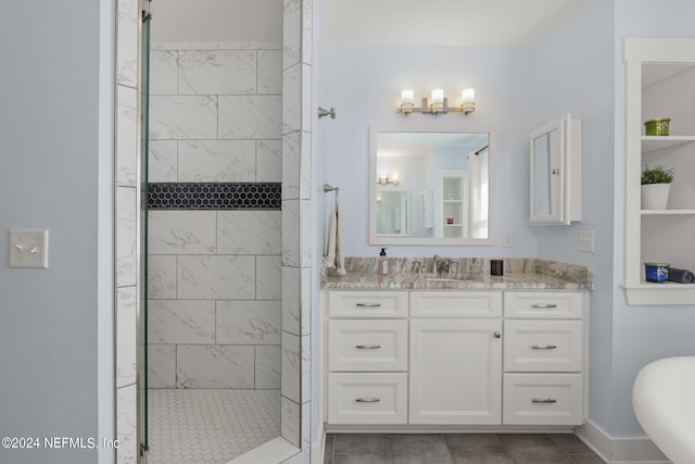 bathroom with vanity, a tile shower, and tile patterned flooring