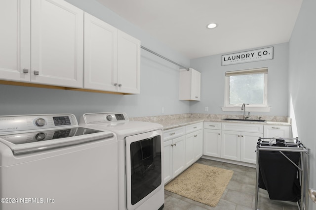 laundry room featuring washing machine and dryer, sink, and cabinets