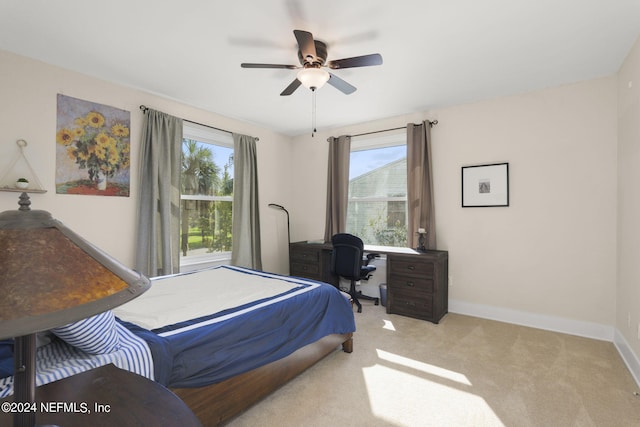 carpeted bedroom featuring ceiling fan and multiple windows