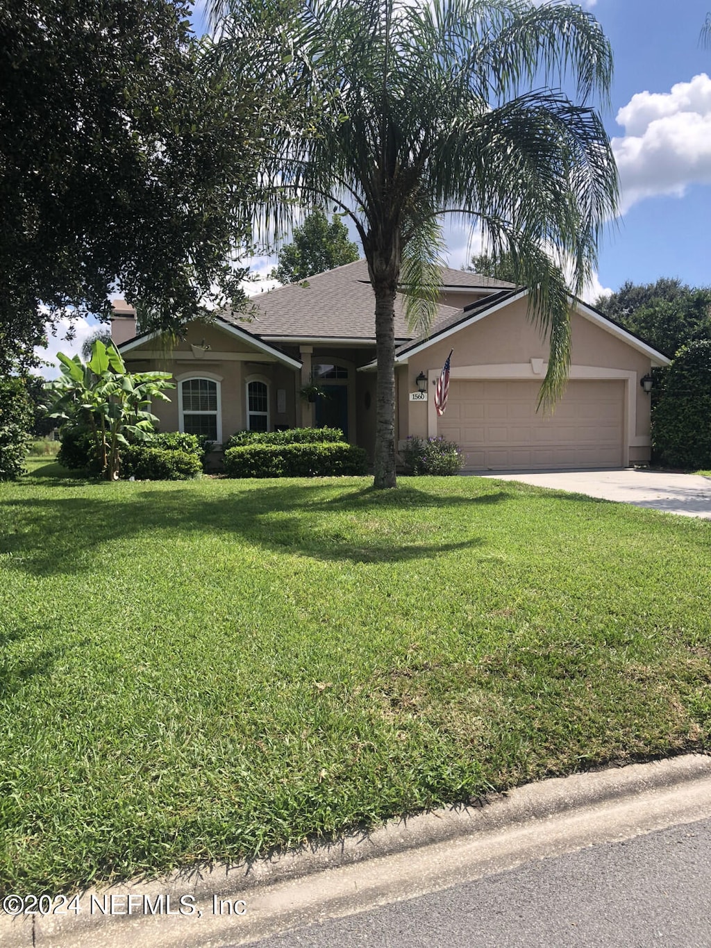 view of front of property with a front yard and a garage