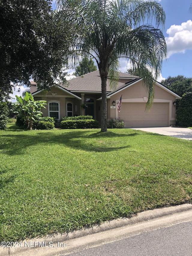 view of front of property with a front yard and a garage