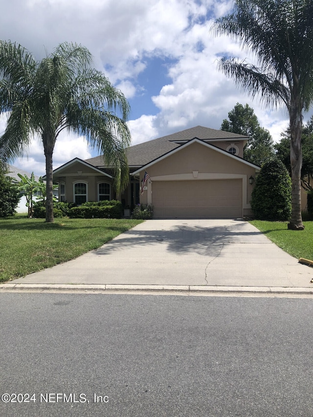 view of front of house with a garage and a front lawn